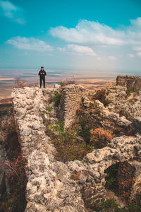 Man standing on rock against landscape