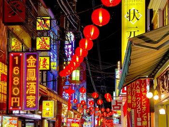 Low angle view of illuminated lanterns hanging on building at night