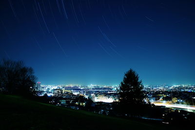 Illuminated cityscape against sky at night