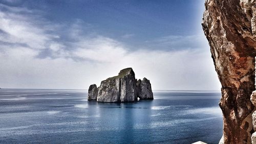 Rock formations in sea against sky