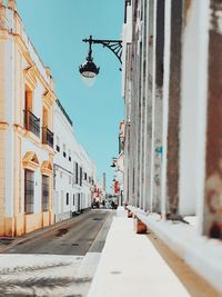 Empty road amidst buildings in city