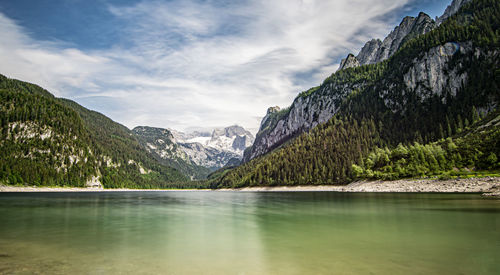 Scenic view of lake by mountains against sky