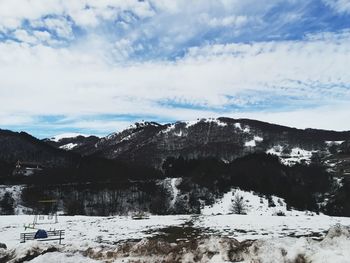 Low angle view of snow covered mountains against sky