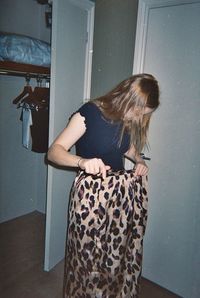 Woman standing against wall at home