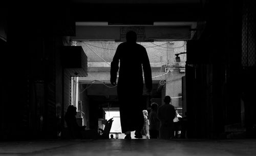 Rear view of silhouette people walking in building