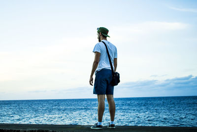 Man standing at beach against sky