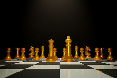 Low angle view of chess board against black background