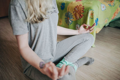 Low section of woman meditating at home