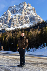 Full length of man standing against snowcapped mountain