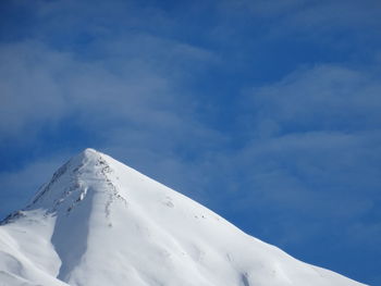 Low angle view of snowcapped mountain against sky