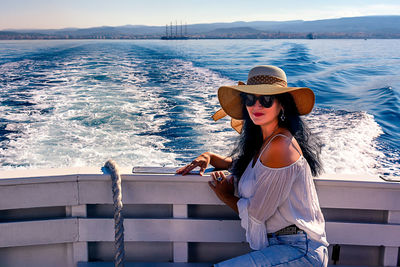 Side view of woman sitting in boat on sea