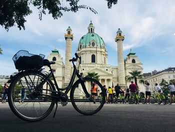 Bicycles by street against buildings in city