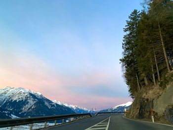 Road amidst snowcapped mountains against sky