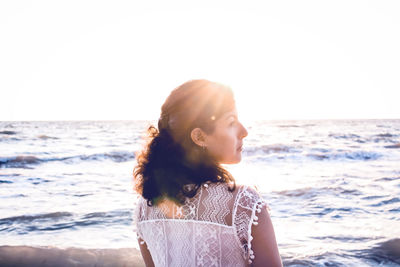 Woman at beach against clear sky