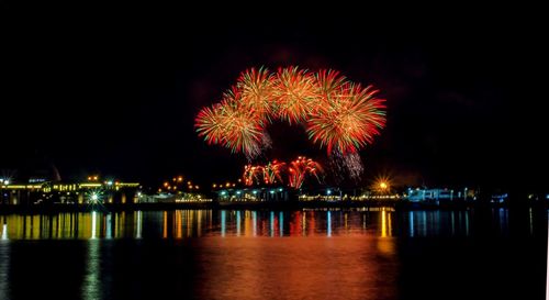 Firework display over sea at night