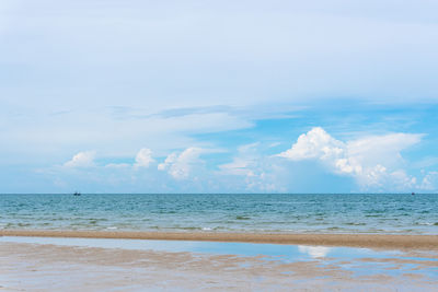 Tropical beach with gentle sea waves and cloudy skies in hua hin, thailand, sea connect to the sky.