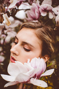 Close-up portrait of woman with pink flower