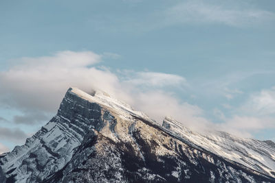 Low angle view of snow covered mountain against sky