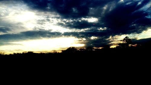 Silhouette of landscape against cloudy sky