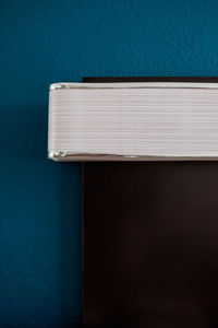 Close-up of open book against blue wall