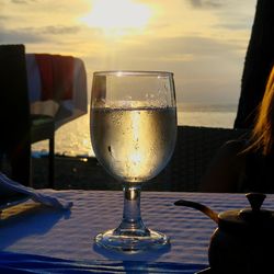 Close-up of wine glass on table at sunset