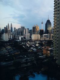 Buildings in city against cloudy sky