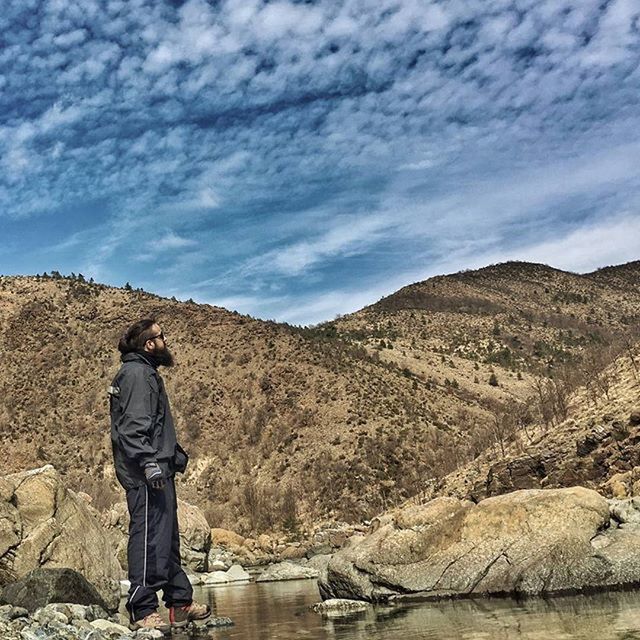 sky, mountain, cloud - sky, tranquility, rock - object, tranquil scene, landscape, scenics, nature, standing, lifestyles, rear view, men, rock formation, beauty in nature, leisure activity, cloud, cloudy