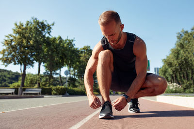 Low section of man exercising on road