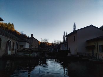 Canal amidst buildings against sky at dusk