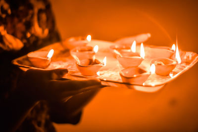 Close-up of lit diwali festival lamps in hand, happy dipawali.