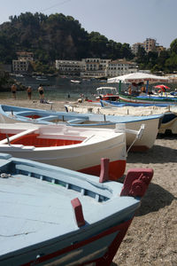 Boats moored on beach against sky