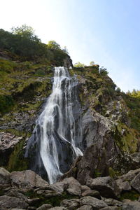 Scenic view of waterfall against sky