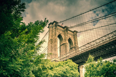 Low angle view of bridge against cloudy sky