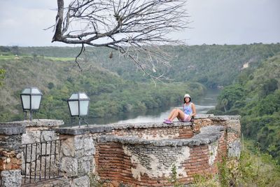 Woman sitting on chair by water