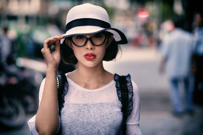 Portrait of woman wearing hat in city