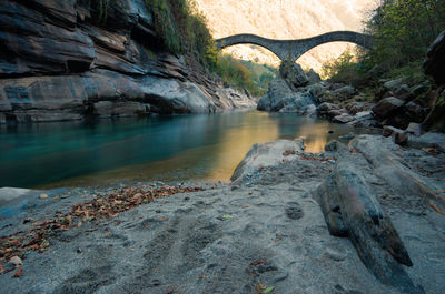 Scenic view of river by tree mountains against sky