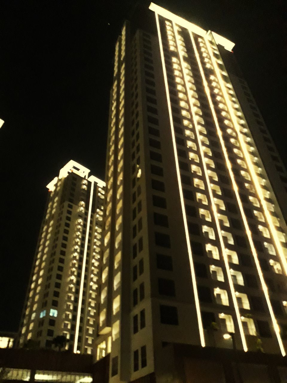 LOW ANGLE VIEW OF ILLUMINATED MODERN BUILDINGS AT NIGHT