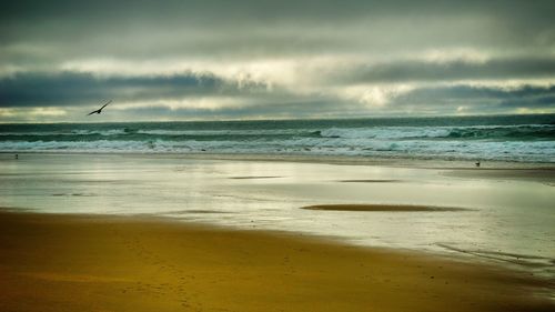 Scenic view of sea against cloudy sky