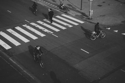 High angle view of people riding bicycle on city street