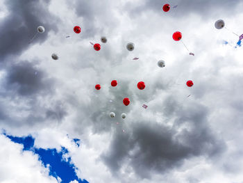 Low angle view of balloons flying against sky