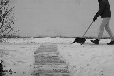 Low section of person with snow shovel on snow