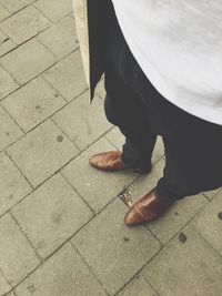 Low section of woman standing on footpath