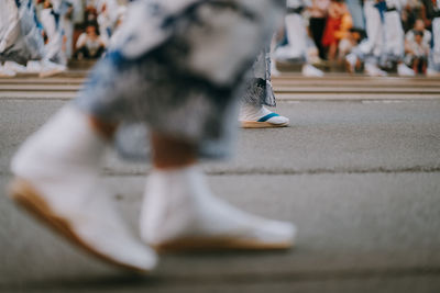 Low section of woman walking on street