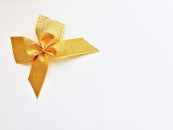 Directly above view of golden ribbon on white background