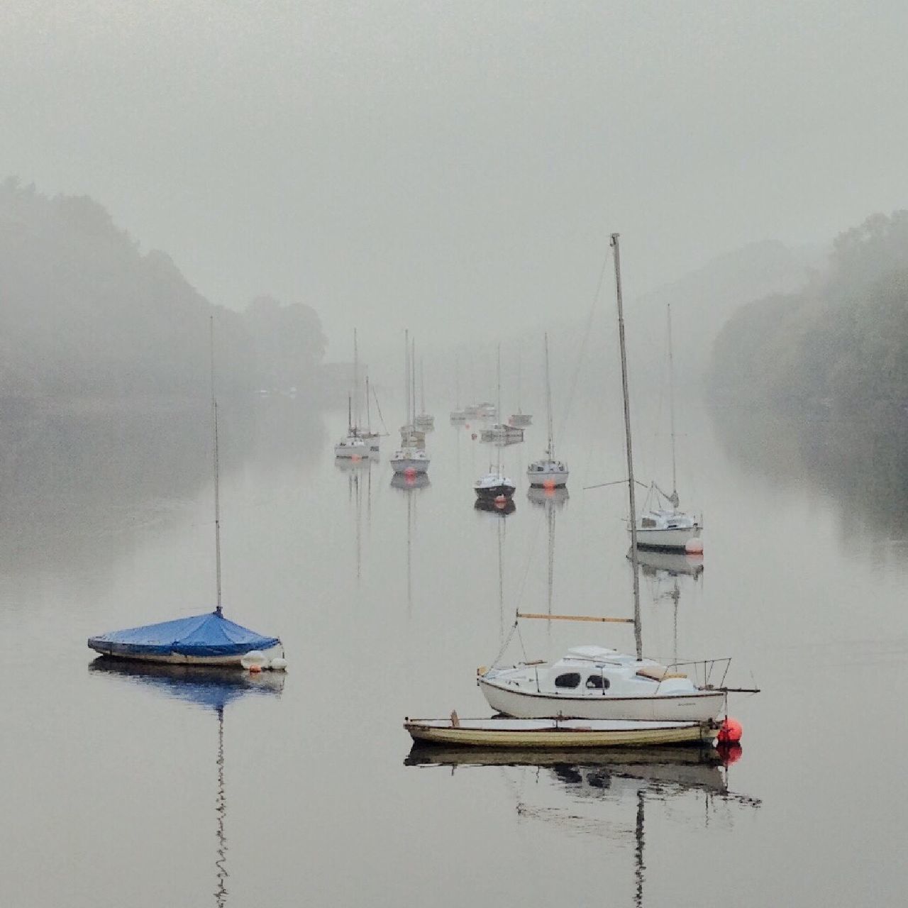 nautical vessel, water, transportation, moored, boat, mode of transport, fog, no people, mast, outdoors, sailboat, nature, tranquility, day, scenics, sea, tranquil scene, waterfront, harbor, beauty in nature, mountain, sailing, sky, yacht, tree