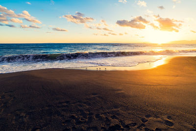 Scenic view of beach against sky during sunset