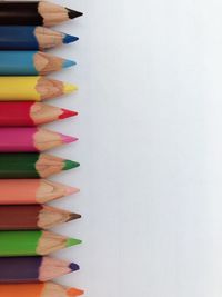 Close-up of multi colored pencils against white background