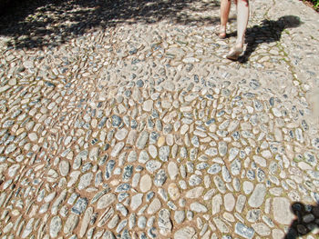 Low section of person standing on pebbles