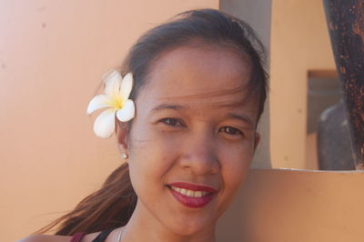 Close-up portrait of smiling woman wearing flower