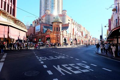 People on road against buildings in city